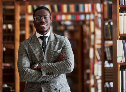 Male Education major stands in the library